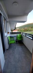 a room with a desk and two green chairs at My Life 20 - Green Hill in Soko Banja