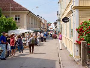 a group of people walking down a street in a town at 27ans Nattlogi in Vadstena