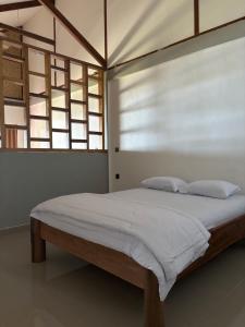 a bedroom with a large bed with white sheets and a window at Onaza Homestay Bintang in Katiet +23 photos