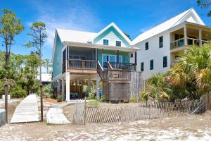 a house on the beach with a fence at Bethany Cottage by Pristine Properties Vacation Rentals in Indian Pass
