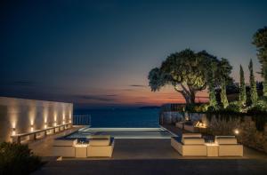 a patio with a view of the ocean at night at Dia Dyo Residences in Pefki