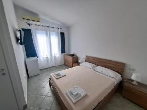 a bedroom with a bed with two towels on it at Su Debieddu Rooms in Solità