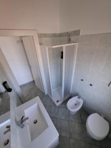 a white bathroom with a sink and a toilet at Su Debieddu Rooms in Solità