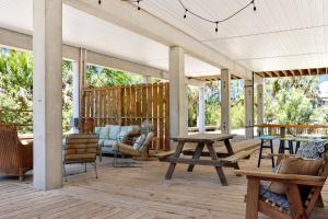 a covered porch with furniture and a table at Bethany Cottage by Pristine Properties Vacation Rentals in Indian Pass