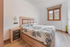 ein Schlafzimmer mit einem Bett und einer Holzkommode in der Unterkunft El Tranco Apartamentos in Villel