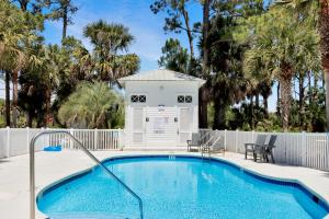 a pool with a dog house next to a building at Bethany Cottage by Pristine Properties Vacation Rentals in Indian Pass
