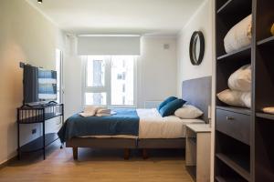 a small bedroom with a bed and a television at Chic Providencia Apt 2BR 2BA Sleeps 5 in Santiago