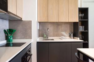 a kitchen with wooden cabinets and a sink at Chic Providencia Apt 2BR 2BA Sleeps 5 in Santiago