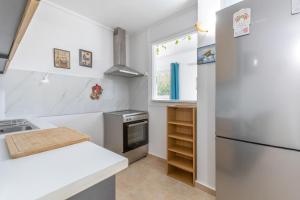 a white kitchen with a refrigerator and a sink at Stella's Olive Tree House in Adelianos Kampos