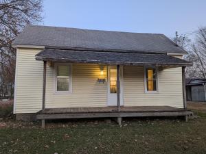 a small white house with a porch and a deck at 2-bedroom house close to Marathon in Robinson