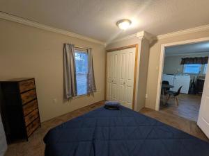 a bedroom with a large blue bed and a dresser at 2-bedroom house close to Marathon in Robinson
