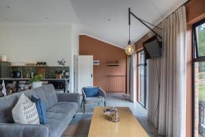 a living room with a couch and a table at Cape Dutch Stay, Suite A in Sedgefield