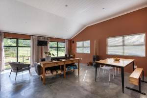 a living room with a table and chairs and windows at Cape Dutch Stay, Suite A in Sedgefield