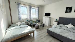 a bedroom with two beds and a living room at Apartmány LENKA in Mikulášovice