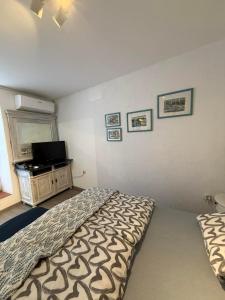 a bedroom with a bed and a flat screen tv at Apartments Rome in Baška