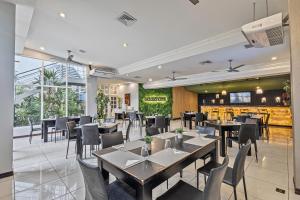 a restaurant with tables and chairs and a tv at Hotel Caña Brava Inn in Cañas