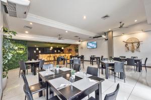 a restaurant with tables and chairs and a tv at Hotel Caña Brava Inn in Cañas