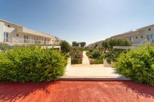 a walkway through a garden at a apartment complex at GuestHost - Borgo 84 Marzamemi - Terrazza Mare in Marzamemi
