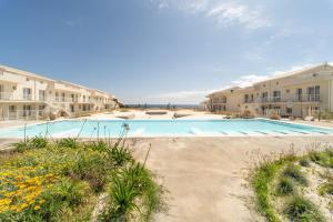 a large swimming pool in front of some apartment buildings at GuestHost - Borgo 84 Marzamemi - Terrazza Mare in Marzamemi