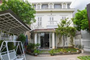 a white house with a white fence at Maison Vy Homestay in Hue