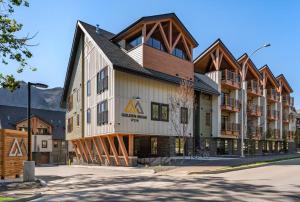 a building on a street with a mountain at Golden Ridge Collection in Canmore