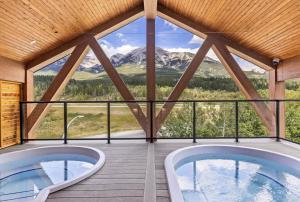 two tubs in a room with a view of mountains at Golden Ridge Collection in Canmore