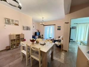 a kitchen and living room with a table and chairs at Mythos House in Palekastron