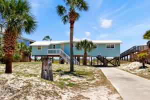 a house on the beach with palm trees at Amethyst Dunes by Pristine Properties Vacation Rentals in Indian Pass