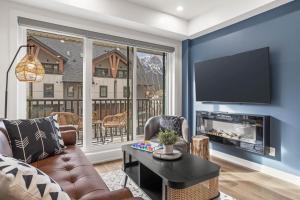 a living room with a couch and a tv at Golden Ridge Collection in Canmore