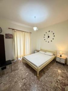 a bedroom with a bed and a clock on the wall at Mythos House in Palekastron