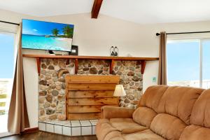 a living room with a couch and a tv on a stone wall at Amethyst Dunes by Pristine Properties Vacation Rentals in Indian Pass