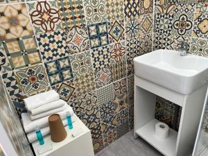 a bathroom with a sink and a mosaic wall at Le Telo in Saint-Mandrier-sur-Mer +28 photos