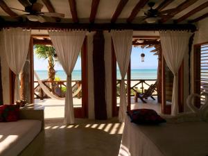 a living room with a view of the beach at Palapas del Sol in Holbox Island +42 photos