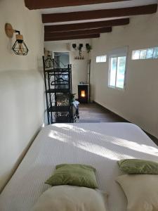 a bedroom with a large white bed with two pillows at Finca rural Labriega del hueznar in Cazalla de la Sierra