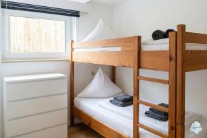 a bedroom with bunk beds and a window at Aviva ANKERPLATZ - Familien-Oase mit Gartenterrasse und 2 Schlafzimmern in Bodman-Ludwigshafen