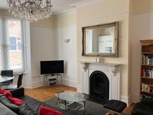 a living room with a fireplace and a mirror at High Street Suites 3 in Ventnor