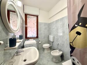 a bathroom with a sink and a toilet and a mirror at Francesca Appartamento con giardino in Levanto