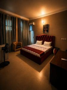 a bedroom with a bed with a red head board at MBL Hotel and Resort in Alakohia