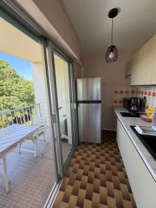 a kitchen with a stainless steel refrigerator and a balcony at Azur Couple Studio in Mandelieu-La Napoule