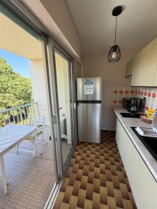 a kitchen with a stainless steel refrigerator and a balcony at Azur Couple Studio in Mandelieu-La Napoule +5 photos