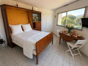 a bedroom with a large bed and a desk and a window at Azur Couple Studio in Mandelieu-La Napoule