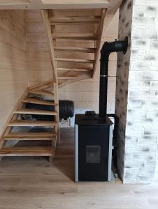 a wood stove in a room with a staircase at Sosnowy Oddech in Samsonów