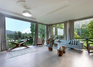 a living room with a glass table and large windows at Haras Ammi Shaddai in Cuitegi