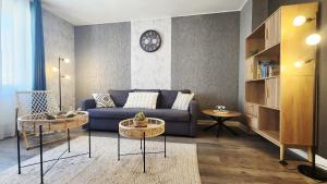 a living room with a blue couch and a clock at Refuge des Rêves in Amnéville