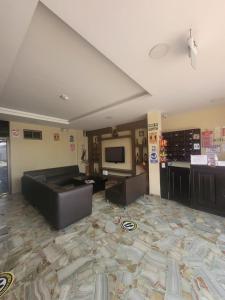a large living room with a couch and a tv at Hotel Confort in Guayaquil