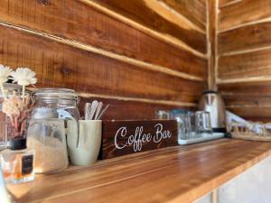 a wooden counter with a coffee bar sign on it at Azuls Tourist Inn in San Vicente
