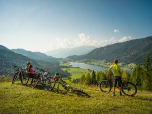 two people with their bikes on a hill overlooking a valley at Haus Stampfer in Weissensee +100 photos