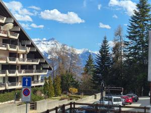 a parking lot in front of a building with mountains at Torgon in Torgon