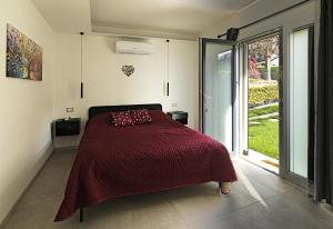 a bedroom with a bed and a large window at Villa Buby in Pettenasco