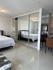 a bedroom with a bed and a large mirror at Flat Lounge 22 Setor Oeste in Goiânia +23 photos